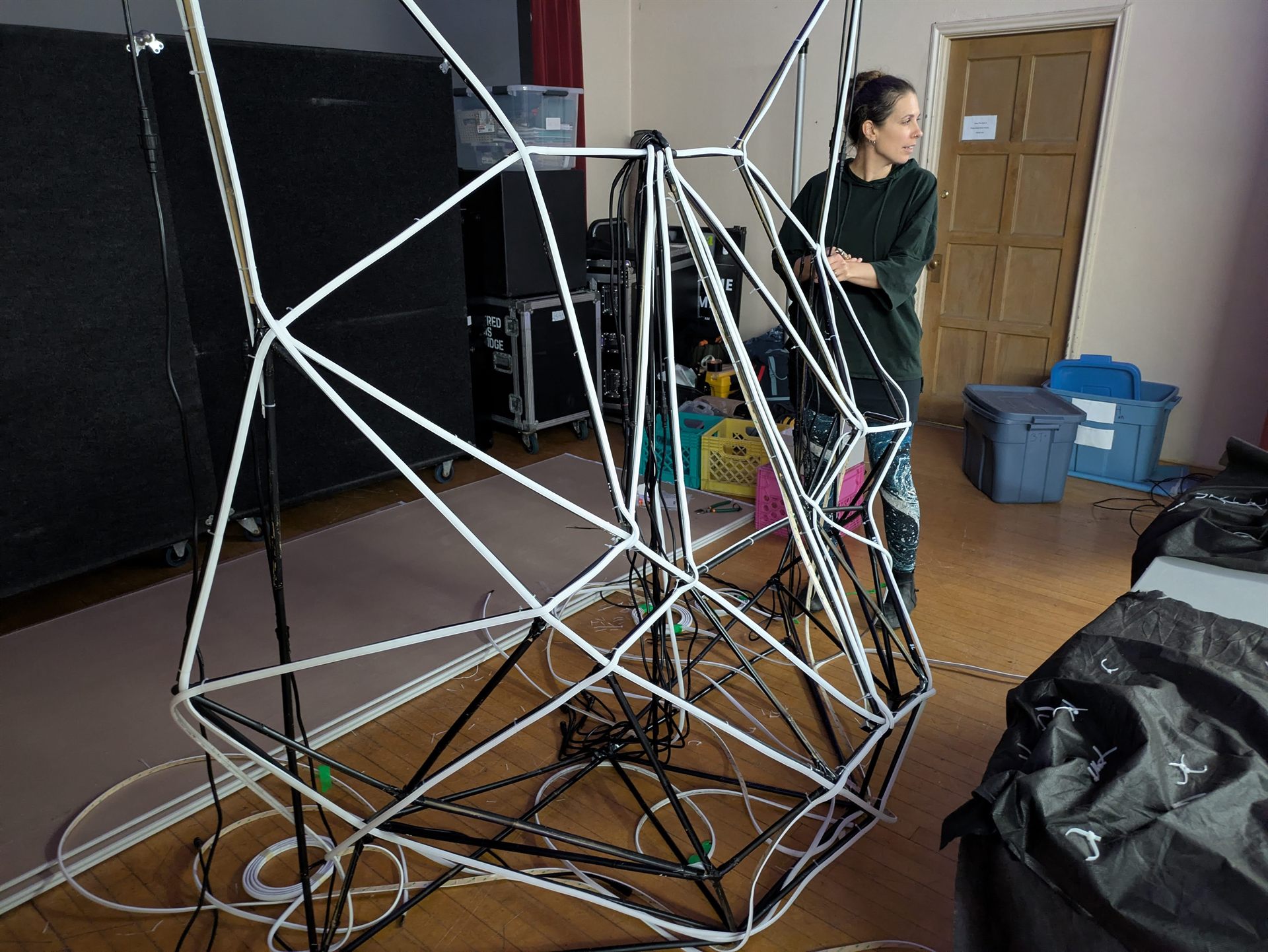 The unlit white frame standing in the hall during setup, showing the bare geometry of the structure.