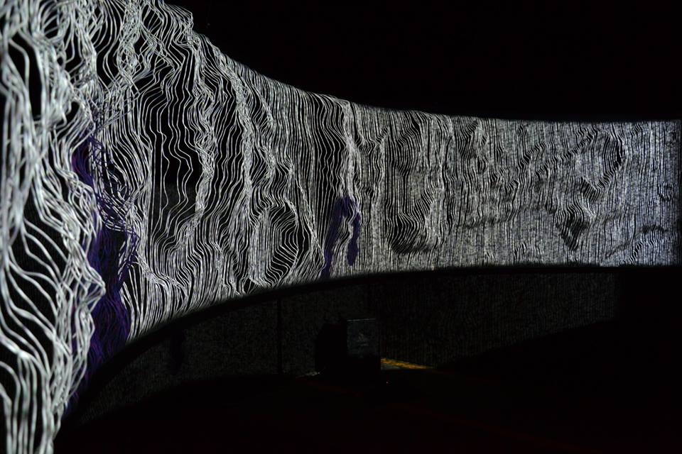 The screen washed in white and violet light, the wire relief reading as a rippled landscape.