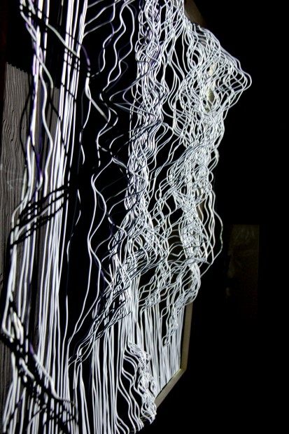 Close view of the white-lit wires against black.